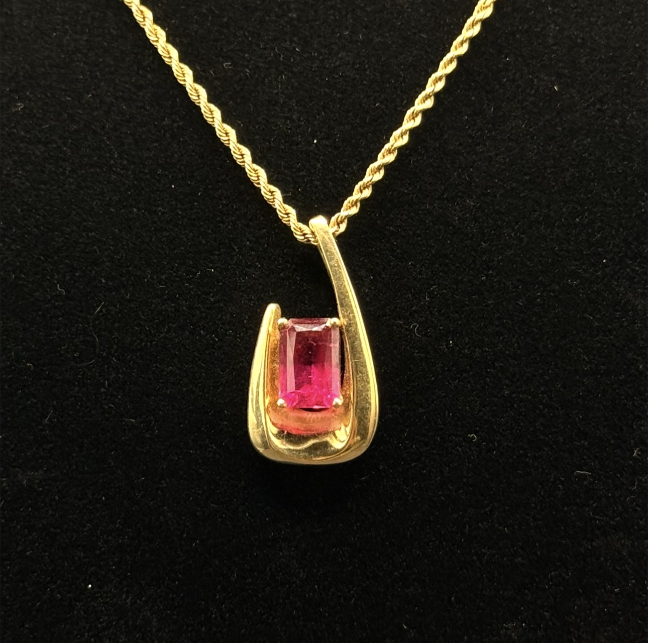 Emerald-cut rubellite tourmaline in gold arc pendant